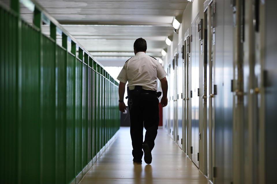 WREXHAM, WALES - MARCH 15:  A prison guard walks through a cell area at HMP Berwyn on March 15, 2017 in Wrexham, Wales. The mainly category C prison is one of the biggest jails in Europe capable of housing around to 2,100 inmates.  (Photo by Dan Kitwood/Getty Images)