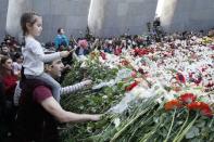 People lay flowers to commemorate the 103rd anniversary of mass killing of Armenians by Ottoman Turks, at the Tsitsernakaberd Memorial Complex in Yerevan, Armenia April 24, 2018. REUTERS/Gleb Garanich