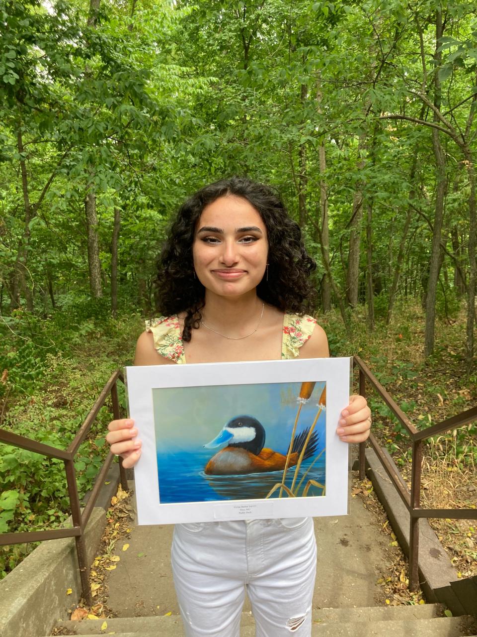 Vivian Bashar, 15, poses for a photo with her painting for the 2022 U.S. Fish & Wildlife Service Junior Duck Stamp Art Contest at the Springfield Conservation Nature Center. Bashar placed second in the third age division.