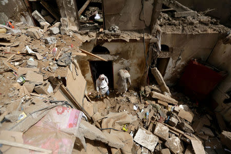 FILE PHOTO: People search in the rubble of a house destroyed by an air strike in Amran, Yemen June 25, 2018. REUTERS/Khaled Abdullah/File Photo