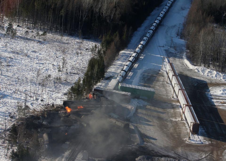 This aerial photo shows derailed train cars burning in Plaster Rock, New Brunswick on Wednesday, Jan. 8, 2014. A Canadian National Railway freight train carrying crude oil and propane derailed Tuesday night in a sparsely populated region of northwestern New Brunswick. More than 100 residents remained evacuated from their homes. There were no deaths or injuries. (AP Photo/The Canadian Press, Tom Bateman)