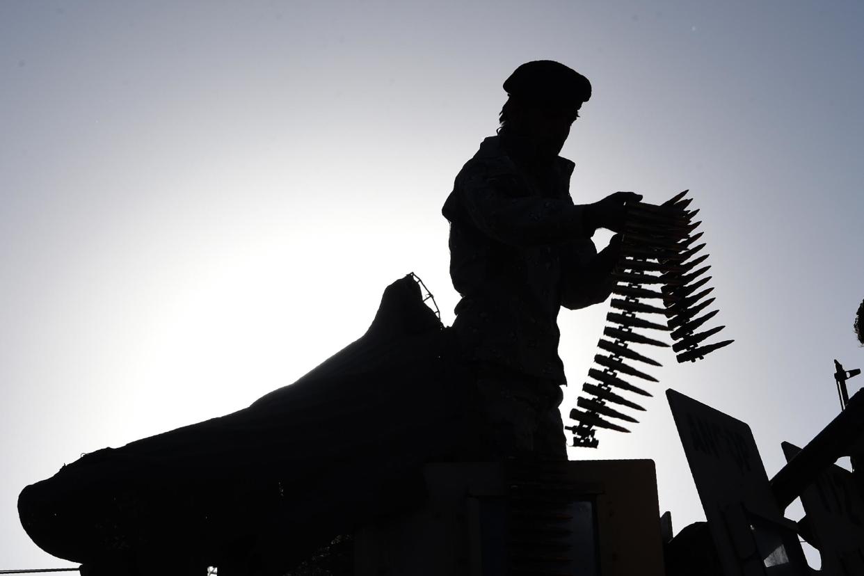 An Afghan security personnel adjusts his weapon as he stands on a armoured humvee vehicle near the Al Zahra mosque in Kabul: AFP/Getty