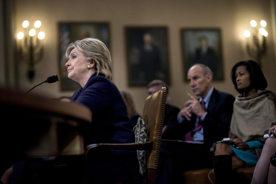 Former Secretary of State Hillary Clinton sits at a table with audience members behind her. (Melina Mara / The Washington Post via Getty Images file)