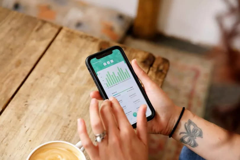 A close up of a women looking at a mobile banking phone app