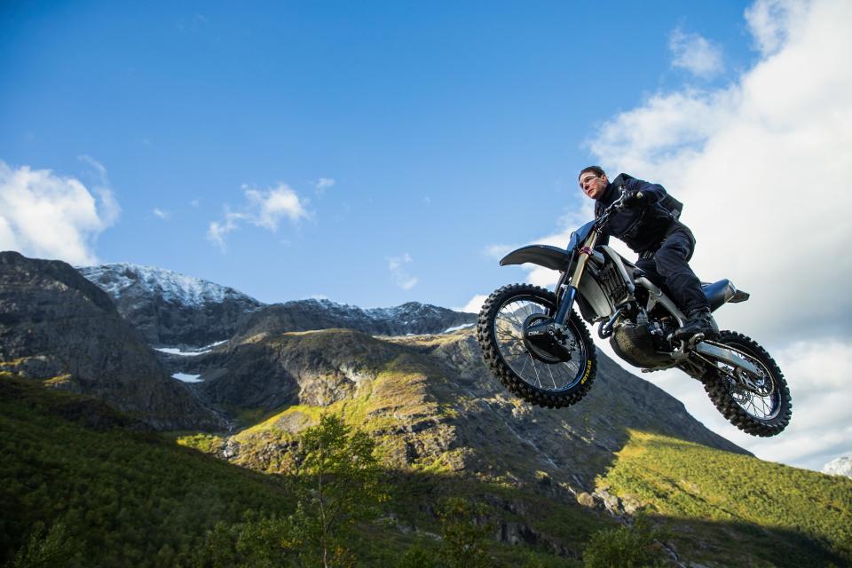 Tom Cruise jumping off a cliff on a motorcycle