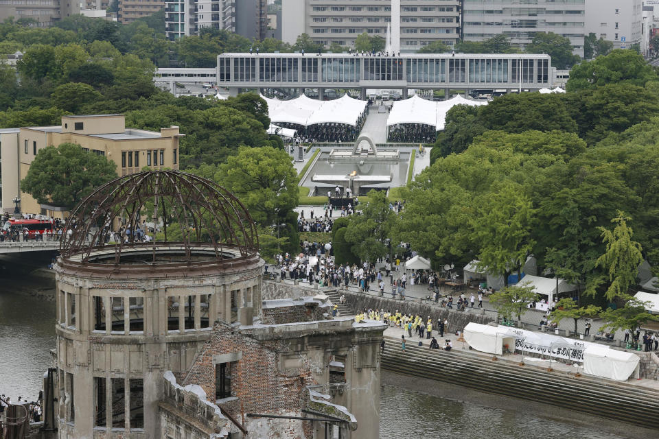 With the Atomic Bomb Dome seen at front, the ceremony marking the anniversary of the bombing is held at the Hiroshima Peace Memorial Park in Hiroshima, western Japan Saturday, Aug. 6, 2022. Hiroshima on Saturday marked the 77th anniversary of the world's first atomic bombing of the city. (Kyodo News via AP)