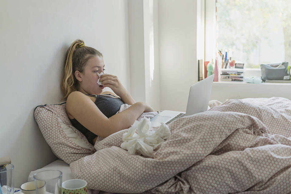 Teenage girl in bed with the flu