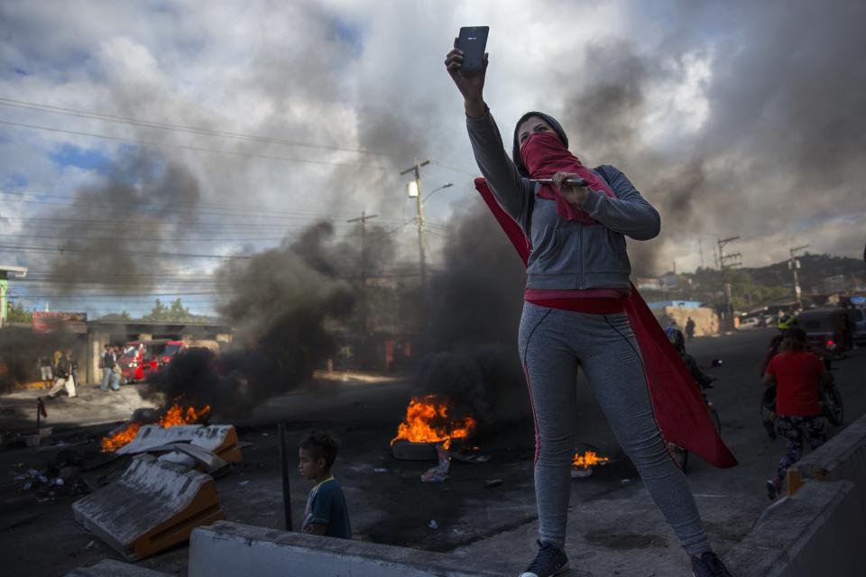 <p>A supporter of presidential candidate Salvador Nasralla takes a selfie at a roadblock set up by people protesting what they call electoral fraud in Tegucigalpa, Honduras, Friday, Dec. 1, 2017. (Photo: Rodrigo Abd/AP) </p>