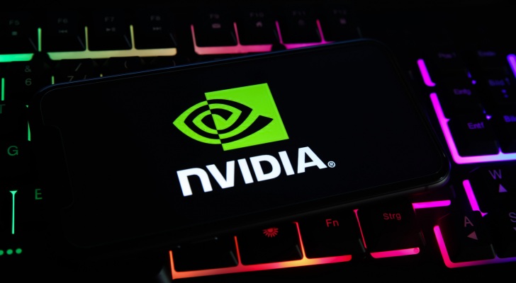 Närbild av mobiltelefonskärm med logotyp bokstäver av nvidia corporation på datorns tangentbord. NVDA aktie.