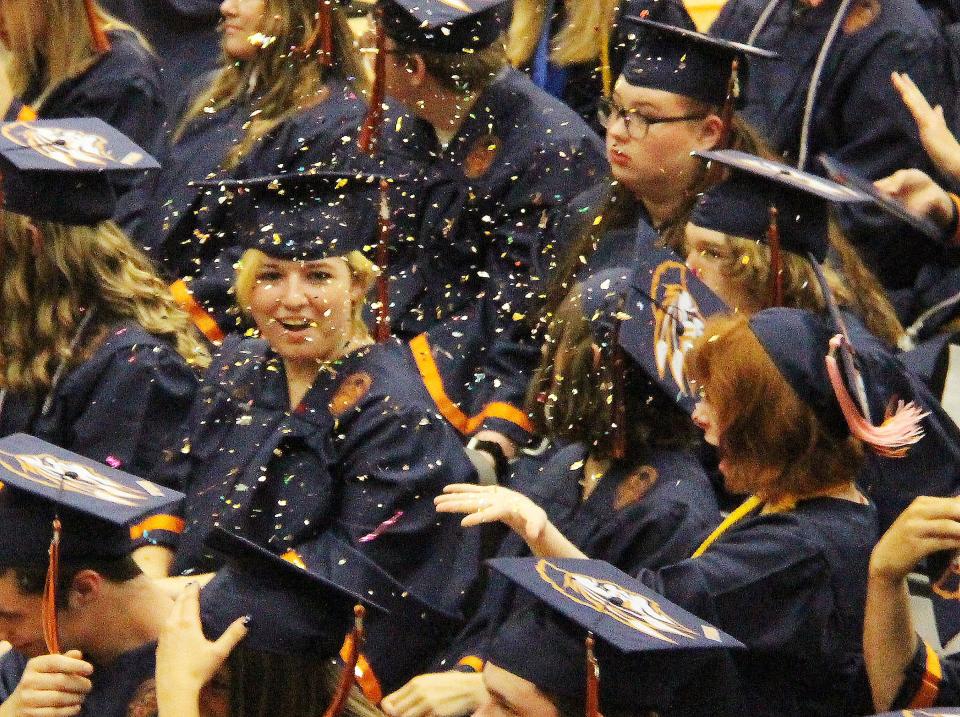 Trina Cooper, left, and Callie Dalton react as confetti is tossed after the traditional turning of the tassel took place to signify official graduation for the Class of 2022 at Pontiac Township High School Sunday.