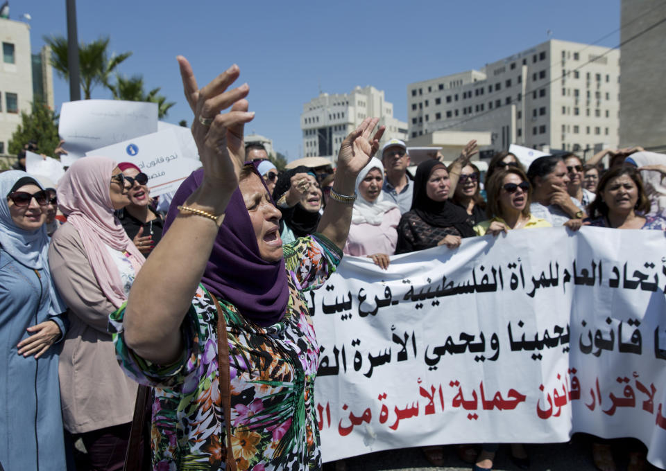 Palestinian women hold a banner that reads, "Palestinian Woman's General Union, we need a law to protect us and to protect the Palestinian family," during a rally in front of the Prime Minister's office, in the West Bank city of Ramallah, Monday, Sept. 2. 2019. Hundreds of Palestinian women protested in front of the prime minister's office to demand an investigation into the death of Israa Ghrayeb, a 21-year-old woman whom many suspect was the victim of a so-called honor killing. (AP Photo/Nasser Nasser)