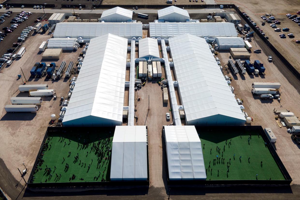 In this March 19 photo, migrants are seen in a green area outside of a soft-sided detention center in Donna, Texas. This is not the facility that Rep. Espaillat toured on Friday.