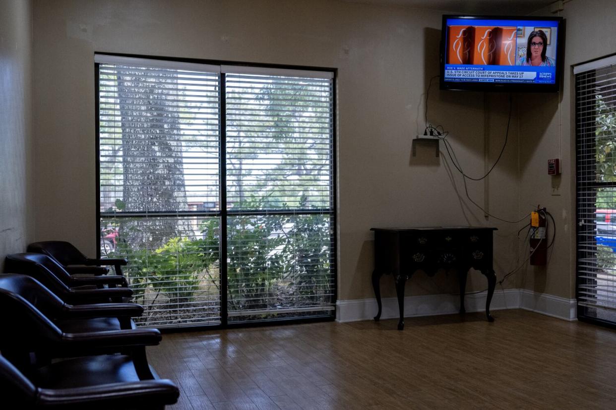 A TV news report plays in an empty waiting room.