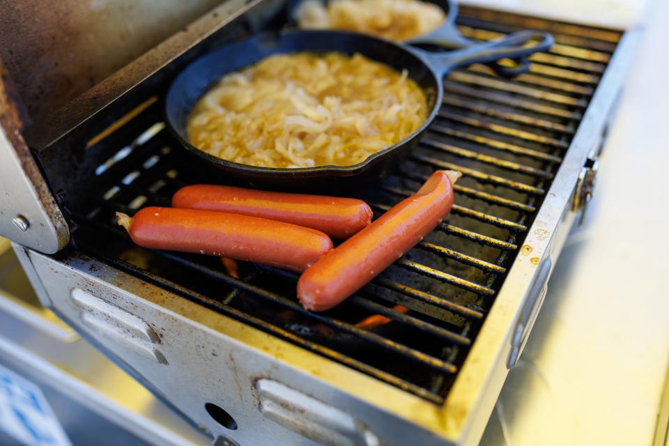 Dogs and onions sit on the grill of The Homedog LLC hot dog cart in the parking lot of WE Sell Sporting Goods at the corner of Pleasant and York Streets, Tuesday, May 21, 2024, in Hanover Borough.