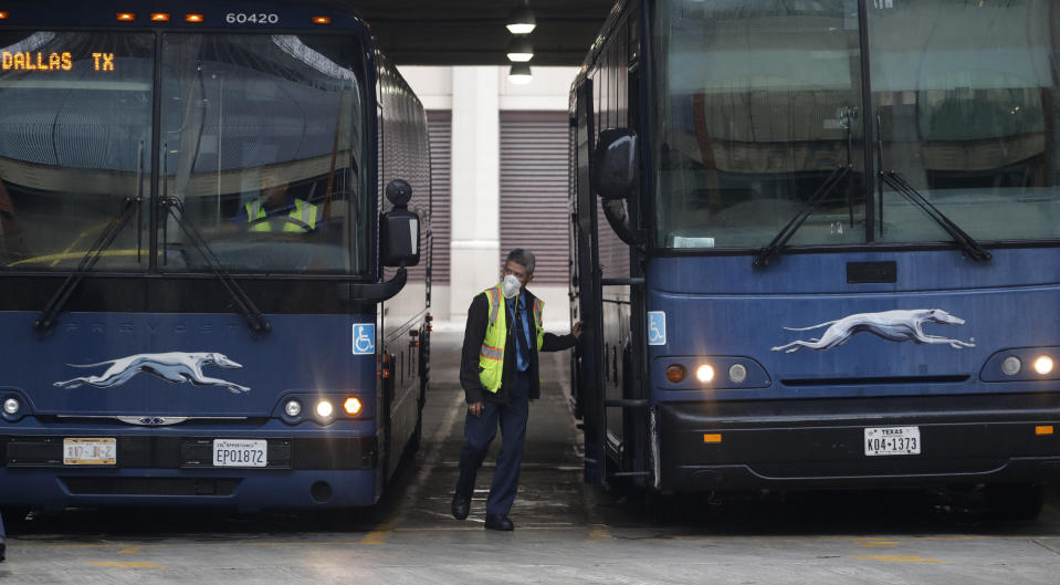 A bus driver wears a face mask as he prepares to board a bus in San Antonio, Wednesday, April 22, 2020. San Antonio remains under stay-at-home orders due to the COVID-19 outbreak and residents are required to wear face coverings or masks whenever in public. (AP Photo/Eric Gay)