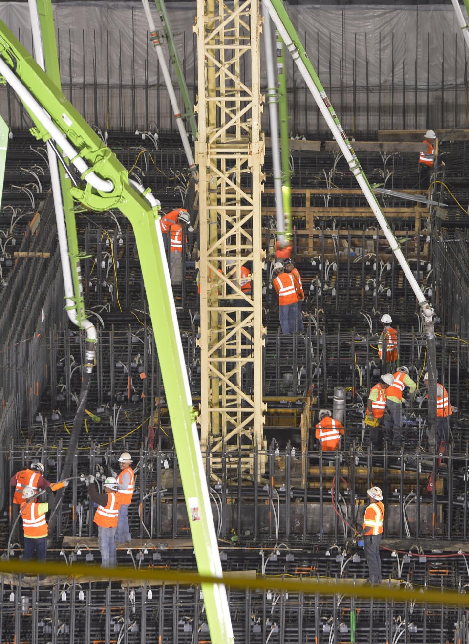 Crews pour concrete to lay the foundation for the New Wilshire Grand building in a record attempt for the largest continuous concrete pour in history, Saturday, Feb. 15, 2014, in downtown Los Angeles. The marathon pour is expected to last 20 hours without interruption. The attempt will be verified by an official from Guinness World Records. The New Wilshire Grand will be the tallest building to be built west of the Mississippi and is expected to be completed in 2017. (AP Photo/Mark J. Terrill)