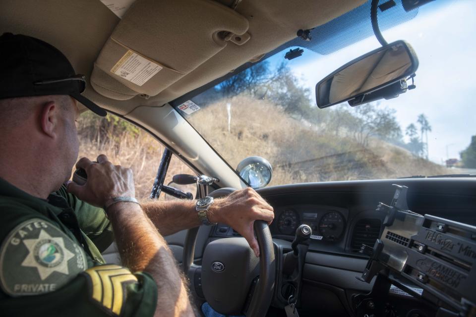 Eric Fine, a private security officer, helps authorities manage traffic and evacuations during a wildfire in the Highlands neighborhood of the Pacific Palisades area of Los Angeles, Monday, Oct. 21, 2019. (AP Photo/Christian Monterrosa)