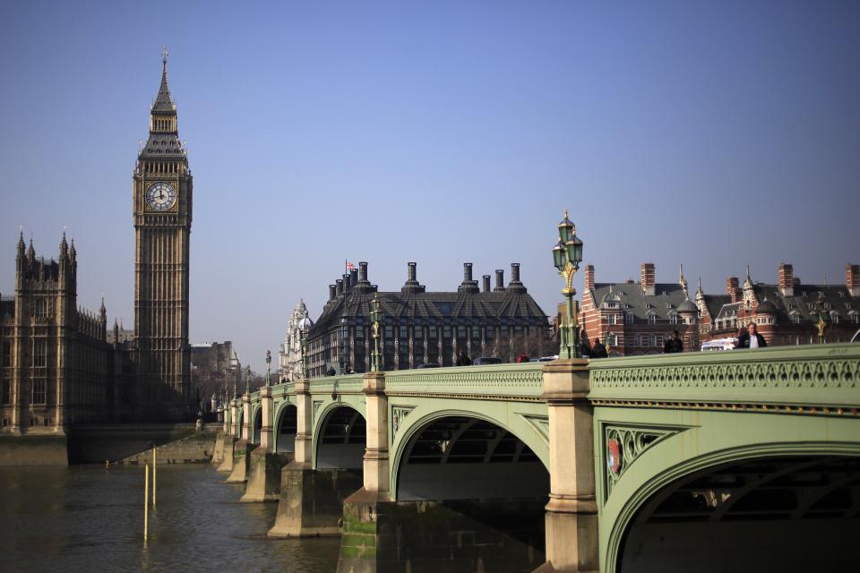 Pedestrians walk across Westminster Bridge in front of the Big Ben Clock Tower, in London March 8, 2011.  REUTERS/Stefan Wermuth (BRITAIN - Tags: TRAVEL CITYSCAPE POLITICS)