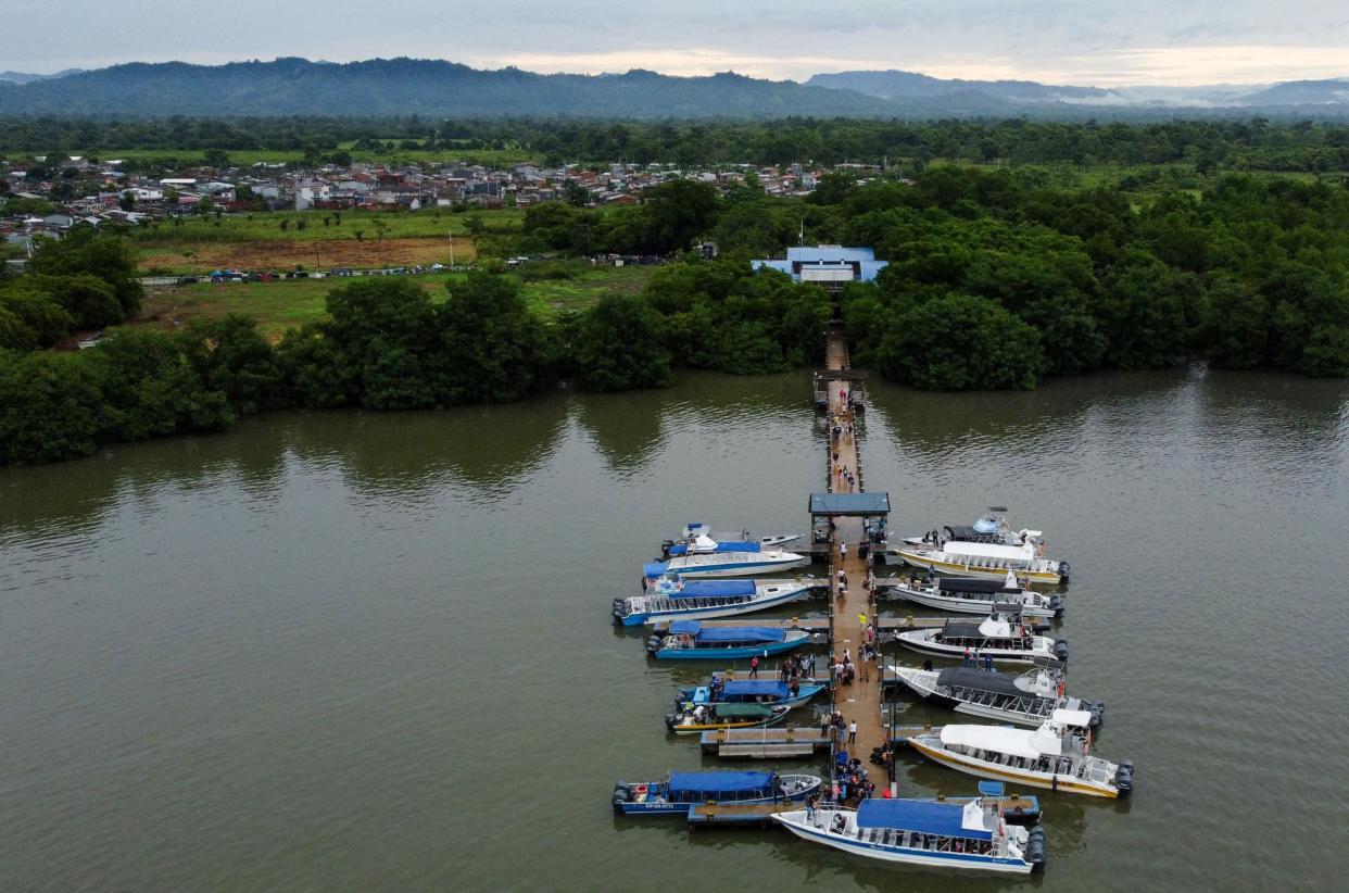 <span>People board boats in the Colombian port town of Turbo, close to the Darién Gap, on 15 September 2023.</span><span>Photograph: Juan Restrepo/AFP via Getty Images</span>