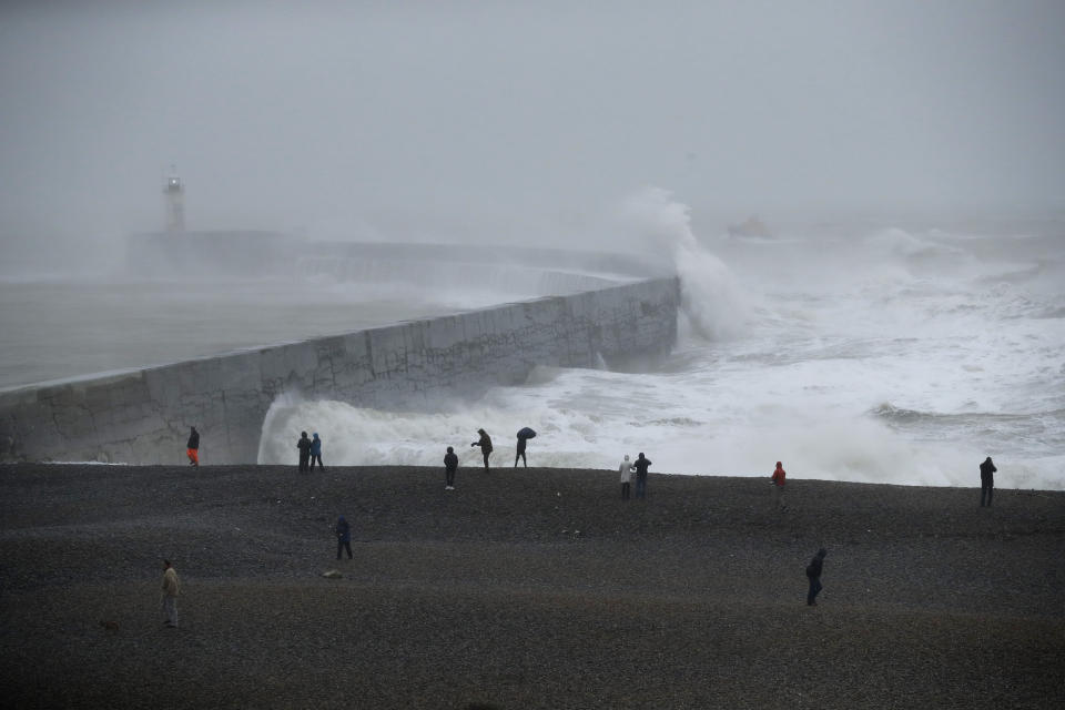 Waves crash over the harbour wall by a lighthouse as a lifeboat passes by at right, as Storm Ciara hits Newhaven, on the south coast of England, Sunday, Feb. 9, 2020. Trains, flights and ferries have been cancelled and weather warnings issued across the United Kingdom and in northern Europe as the storm with winds expected to reach hurricane levels batters the region. (AP Photo/Matt Dunham)