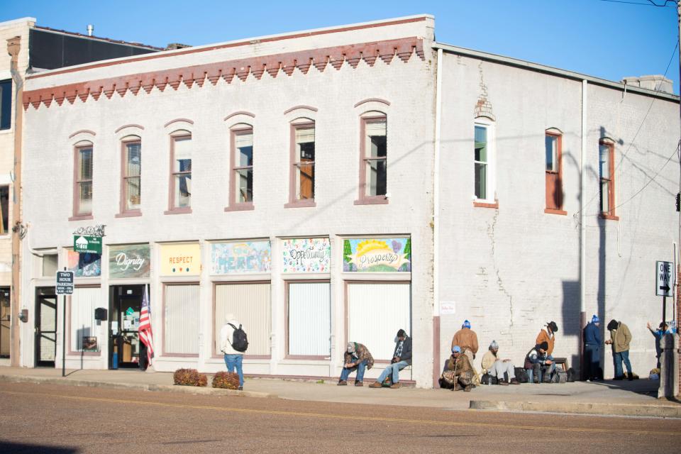 People huddle outside the Area Relief Ministries building in Downtown Jackson as they seek a room inside on Tuesday, Dec. 19, 2023.