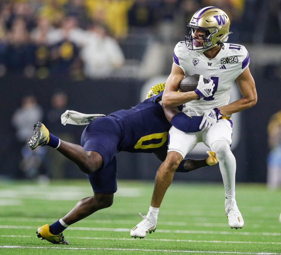 Michigan defensive back Mike Sainristil (0) tackles Washington wide receiver Jalen McMillan (11) during the first half of the national championship game at NRG Stadium in Houston on Monday, Jan. 8, 2024.