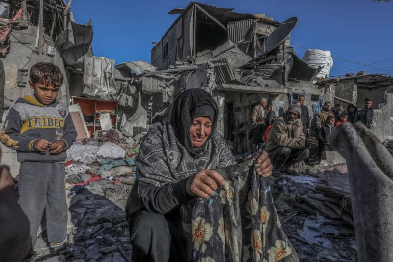 A Palestinian woman cries as she inspects damages after an Israeli air strike on a house belonging to the Zamili family in the city of Rafah in the southern Gaza Strip. 16 people were killed, according to the Gaza Ministry of Health. Abed Rahim Khatib/dpa