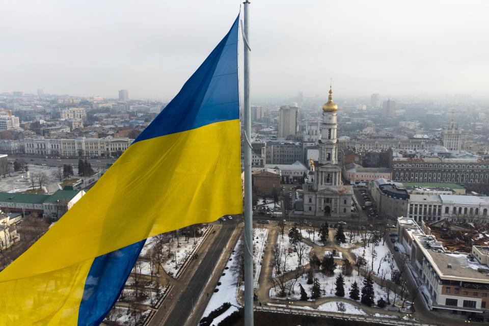 A Ukrainian national flag waves over the center of Kharkiv, Ukraine's second-largest city, Wednesday, Feb. 16, 2022, just 40 kilometers (25 miles) from some of the tens of thousands of Russian troops massed at the border of Ukraine, feels particularly perilous. As Western officials warned a Russian invasion could happen as early as today, the Ukrainian President Zelenskyy called for a Day of Unity, with Ukrainians encouraged to raise Ukrainian flags across the country. (AP Photo/Mstyslav Chernov) ORG XMIT: FP517