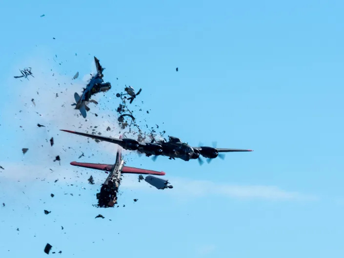 A Boeing B-17 Flying Fortress, front, is seen seconds before colliding with a Bell P-63 Kingcobra in the midair during an airshow at Dallas Executive Airport in Dallas, Saturday, Nov. 12, 2022.