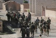 Turkey-backed Syrian rebel fighters walk together near the border town of Tel Abyad