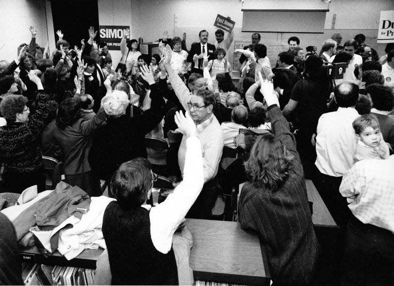 Hanawalt Elementary School was the site of four separate caucuses in 1988. Here supporters mostly of candidate Paul Simon raise their hands for a show of strength.