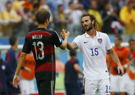 Germany's Thomas Mueller (L) shakes hands with Kyle Beckerman of the U.S. at the end of their 2014 World Cup Group G soccer match at the Pernambuco arena in Recife June 26, 2014. REUTERS/Brian Snyder