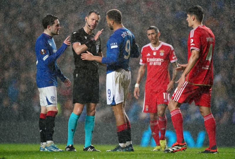 Referee Ivan Kruzliak speaks with Rangers' Cyriel Dessers during the UEFA Europa League Round of 16, second leg soccer match between Rangers and Benfica at the Ibrox Stadium. Andrew Milligan/PA Wire/dpa