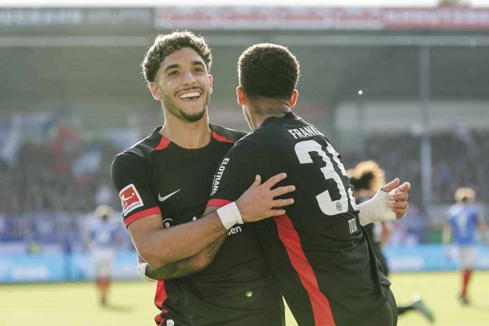 Frankfurt's Omar Marmoush, left, and Lucas Tuta-Silva Melo celebrate after scoring their side's fourth goal during the Bundesliga soccer match between Holstein Kiel and Eintracht Frankfurt, at the Holstein Stadium in Kiel, Germany, Sunday, Sept. 29, 2024. (Frank Molter/dpa via AP)