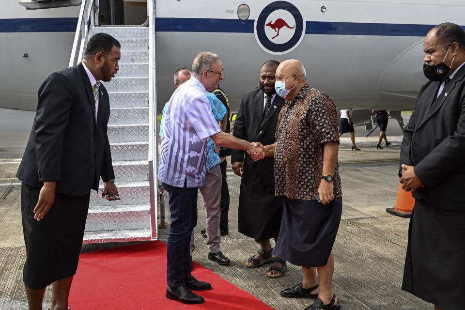 Australian Prime Minister Anthony Albanese, second left, is met by Ratu Inoke Kubuobola, Fiji Special Envoy to the Pacific, as he arrives in, Suva, Fiji, Wednesday, July 13, 2022. Albanese is attending the Pacific Islands Forum meeting as China vies for more influence in the Indo-Pacific region. (Joe Armao/Pool via AP)
