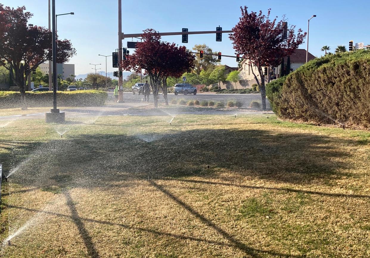 <p>Sprinklers water grass near a street corner on 9 April, 2021, in the Summerlin neighborhood of Las Vegas</p> (AP)