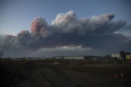 A massive plume of smoke, from a wildfire north of the city, stretches over Fort McMurray, Alberta, Canada Wednesday evening, May 5, 2016. Courtesy Chris Schwarz/Government of Alberta/Handout via REUTERS