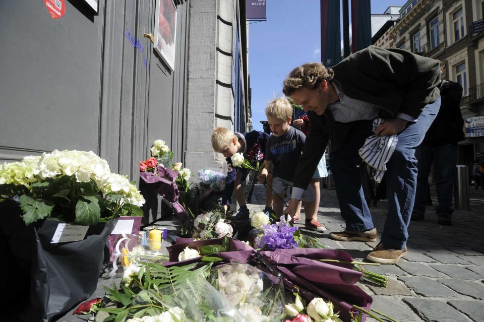 People place flowers at the entrance of the Jewish Museum, the site of Saturday's shooting, in Brussels