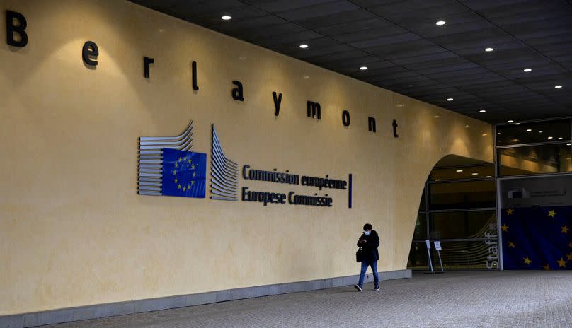 A man walks past the entrance to the EU headquarters in Brussels, December 2020