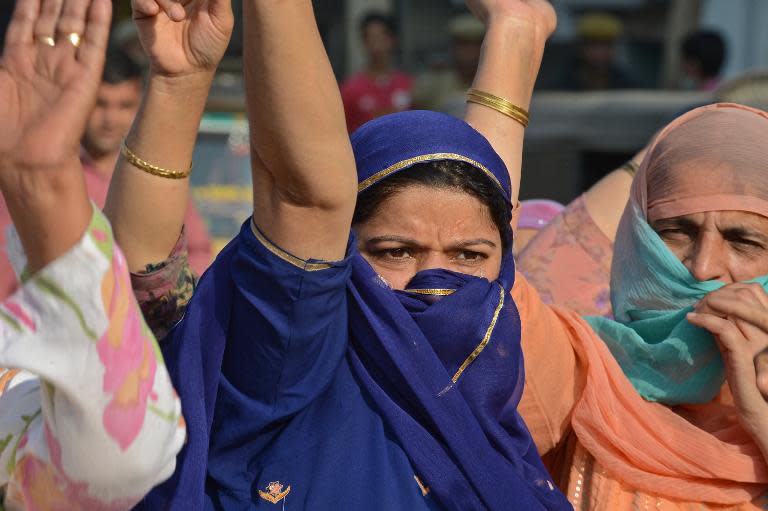 Food-affected Kashmiri's plead for relief material and shout anti-government slogans during a protest in Srinagar on October 3, 2014