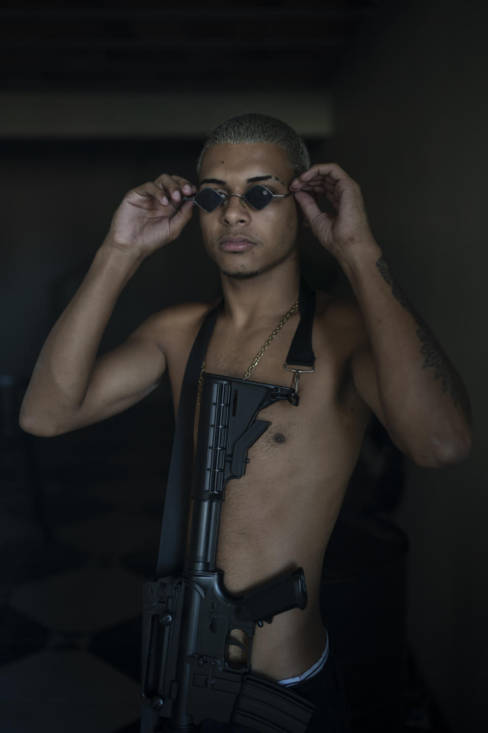 Trap artist Filipe Toledo, known as “Lindinho 22,” poses for a photo with an Airsoft gun during the recording of a 'Trap de Cria' music video in the Jardim Catarina community in Sao Gonçalo, Rio de Janeiro state, Brazil, Sunday, April 11, 2021. “Our weapon is our voice, our ammunition is our lyrics,” Toledo said. (AP Photo/Felipe Dana)