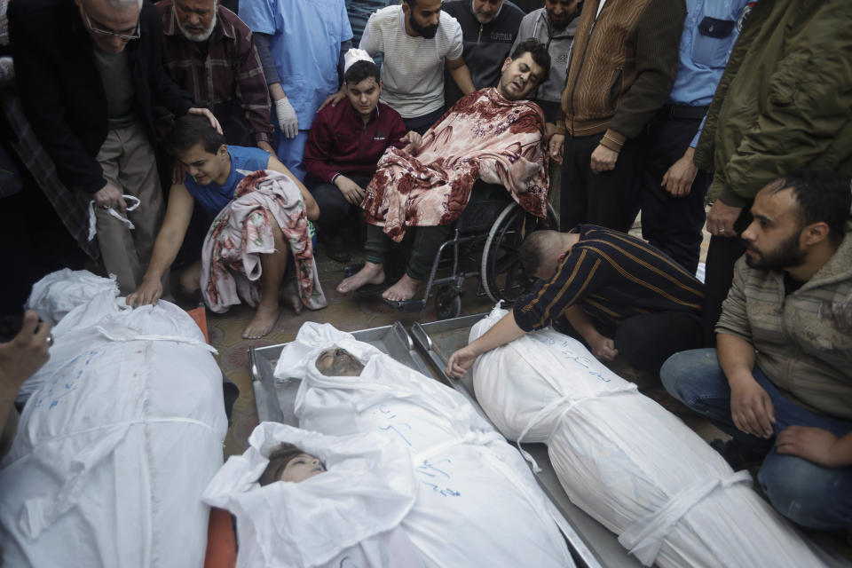 Palestinians mourn over the bodies of their relatives were killed in Israeli bombardments, at the Nasser hospital in Khan Younis refugee camp, southern Gaza Strip, Monday, Dec. 4, 2023. (AP Photo/Mohammed Dahman)