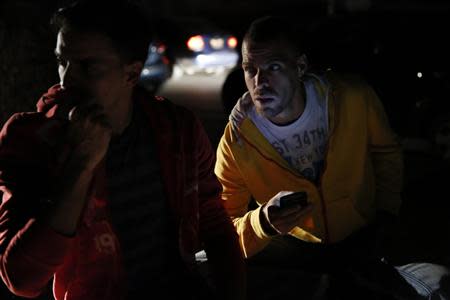 People wait on the street for the power to return after a blackout in Caracas December 2, 2013. REUTERS/Carlos Garcia Rawlins