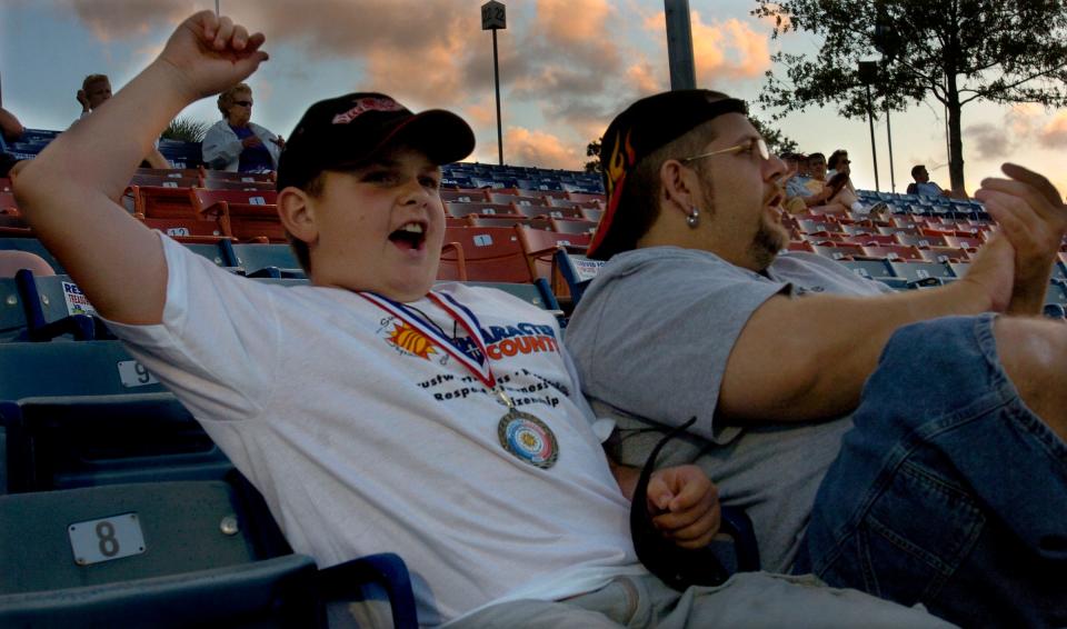 Spencer Hojdila, a fifth-grade student at Citrus Elementary School in Vero Beach, cheers a third inning play along side his father Ted Santana as the Sarasota Reds visited the Vero Beach Dodgers inside Holman Stadium in Vero Beach, Florida, Friday May 13, 2005. Hojdila was one of 78 children attending the annual Character Counts Night at the stadium, which honors six children in kindergarten through fifth grade from each of the 13 public elementary schools in Indian River County. "I think it's pretty neat and happy I got chosen" Hojdila said. "Happy my parents taught me to do the right things."