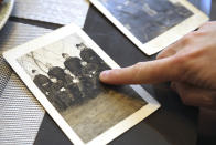 Julien Bensimhon points to Israel Fisse, Eugenie Cayet's father, in his World War II French Army uniform on a photograph Wednesday, Oct.13, 2021 in Paris. Israel Fisse was deported in September 1942 to Auschwitz, in what was then Nazi-occupied Poland, where he was killed. Critics of Eric Zemmour, a rabble-rousing television pundit and author with repeated convictions for hate speech, include people like Cayet, who lost relatives to the Holocaust. They are outraged by his repeated comments that have sugarcoated wartime France's collaboration with the extermination of French Jews. (AP Photo/John Leicester)