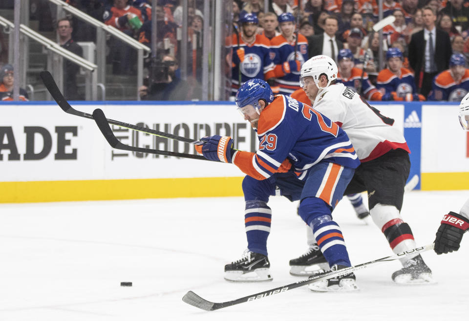 Ottawa Senators' Jakob Chychrun (6) and Edmonton Oilers' Leon Draisaitl (29) vie for the puck during the second period of an NHL hockey game Saturday, Jan. 6, 2024, in Edmonton, Alberta. (Jason Franson/The Canadian Press via AP)