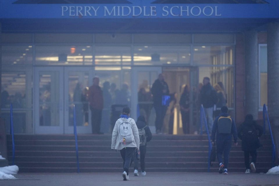 Students arrive at Perry Middle School, Thursday, Jan. 25, 2024, in Perry, Iowa. Middle school students returned to classes Thursday for the first time since a high school student opened fire in a shared cafeteria, killing two people and injuring six others. (AP Photo/Charlie Neibergall)