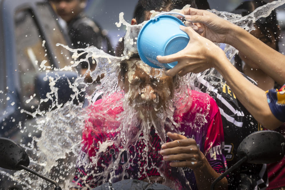 A man reacts as a bucket of water is splashed on him during the Songkran water festival to celebrate the Thai New Year in Prachinburi Province, Thailand, Saturday April 13, 2024. It's the time of year when many Southeast Asian countries hold nationwide water festivals to beat the seasonal heat, as celebrants splash friends, family and strangers alike in often raucous celebration to mark the traditional Theravada Buddhist New Year. (AP Photo/Wason Wanichakorn)