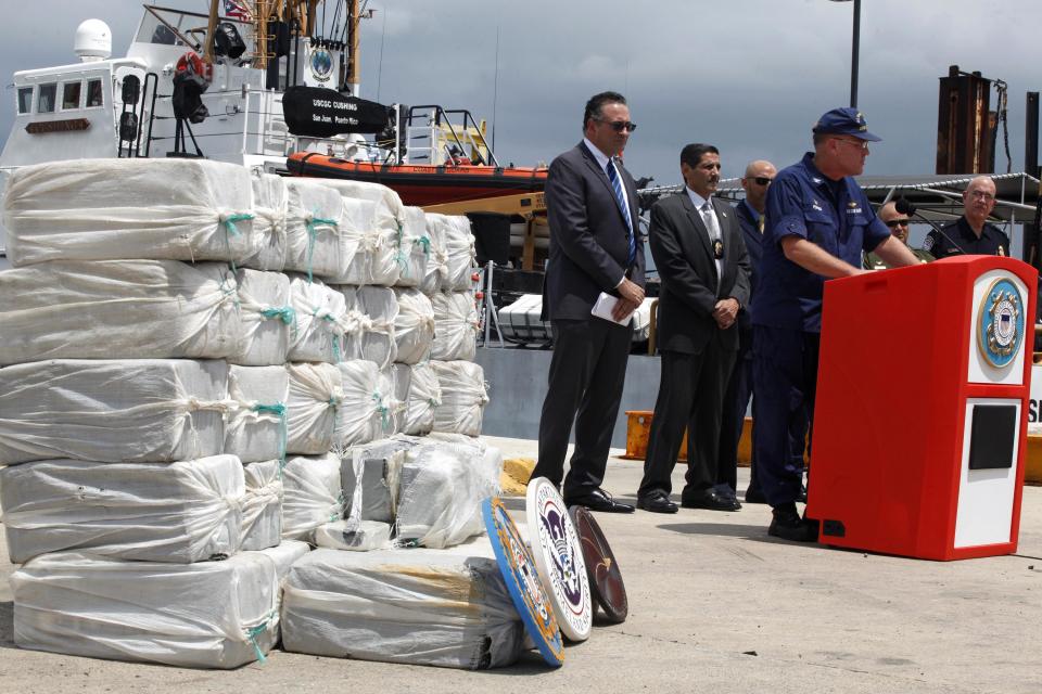 U.S. Coast Guard Captain Drew W. Pearson (2nd R), San Juan sector commander, speaks during a media presentation for cocaine that were seized on April 29 during an at-sea interdiction south of Puerto Rico, in San Juan, May 6, 2014. The Coast Guard recovered 1280 kg (2822 pounds) of cocaine, worth an estimated $37 million, during a routine patrol and also arrested two traffickers from the Dominican Republic. REUTERS/Ana Martinez (PUERTO RICO - Tags: CRIME LAW DRUGS SOCIETY)