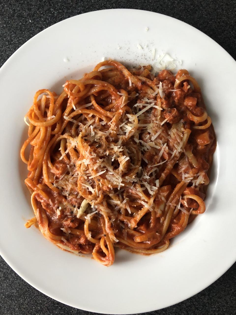 Plate of spaghetti with tomato sauce and grated cheese on top